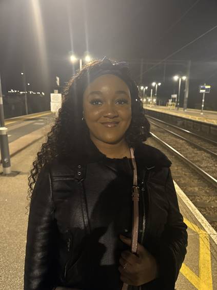 Debbie, founder of The Bibi Edit standing at a train station at night.
