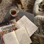 Journal ouvert sur une table en bois avec un café et un livre français