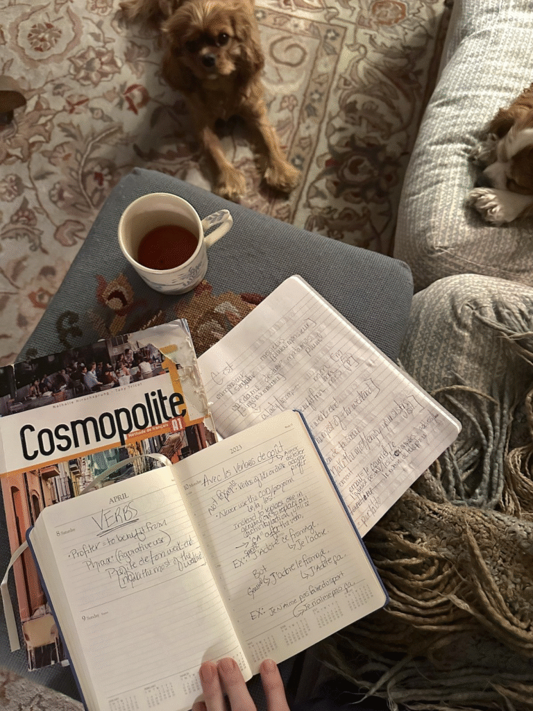 Journal ouvert sur une table en bois avec un café et un livre français